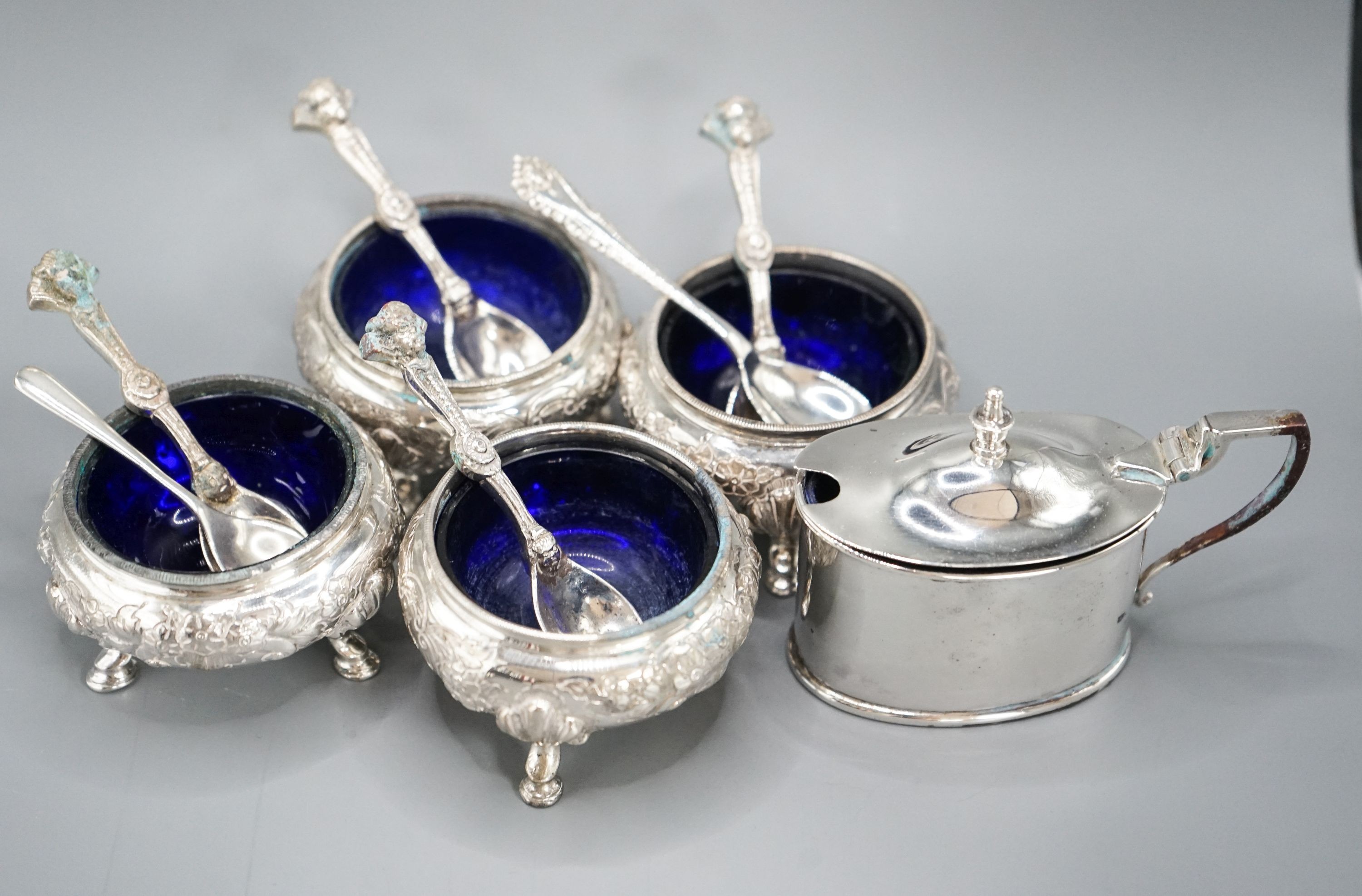 A set of four Victorian silver bun salts, Sheffield, 1869 and four associated silver spoons and a later silver mustard pot and two spoons.